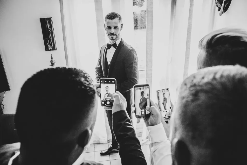 Photographie préparatifs mariage en noir et blanc - Les invités prennent en photo le mariée avec leu r téléphone Yvelines 78