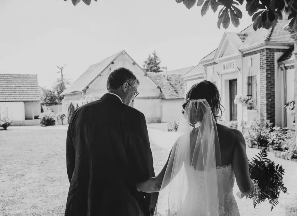 La mariée au bras de son papa pour l'entrée de la mairie - Photographe Mariage Rev'Eure